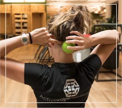 Home 26 an Active Edge specialist demonstrating how to release neck tension with a tennis ball