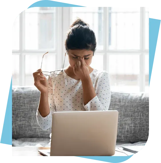 Woman with a migraine headache sitting at her computer in Columbus