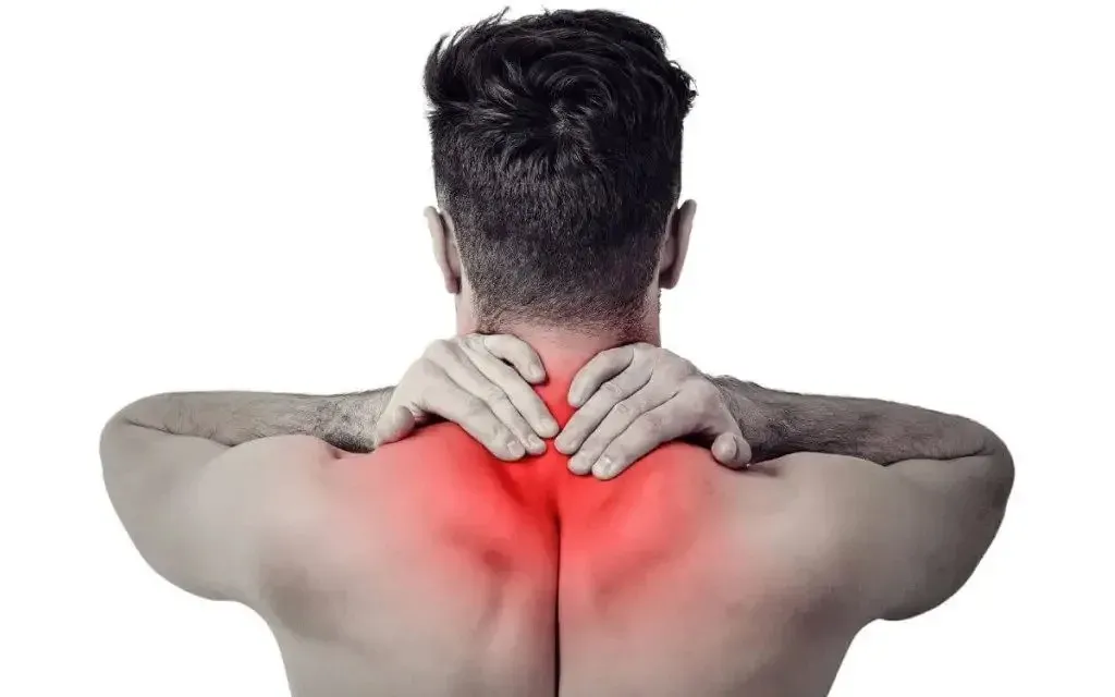 a man holding his lower neck that is suffering from Fibromyalgia flare ups