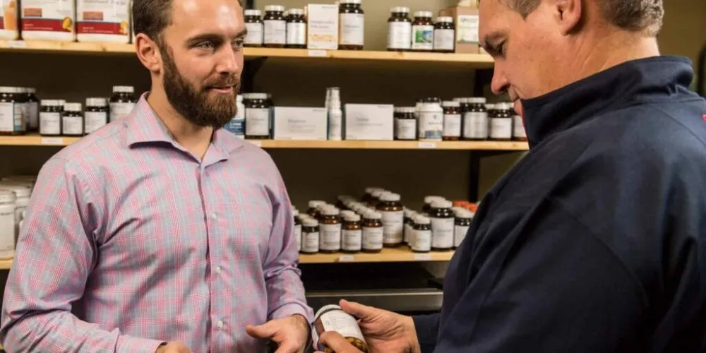 Dr. Erik Hansel explaining nutritional supplements to a patient in Active Edge Columbus Ohio